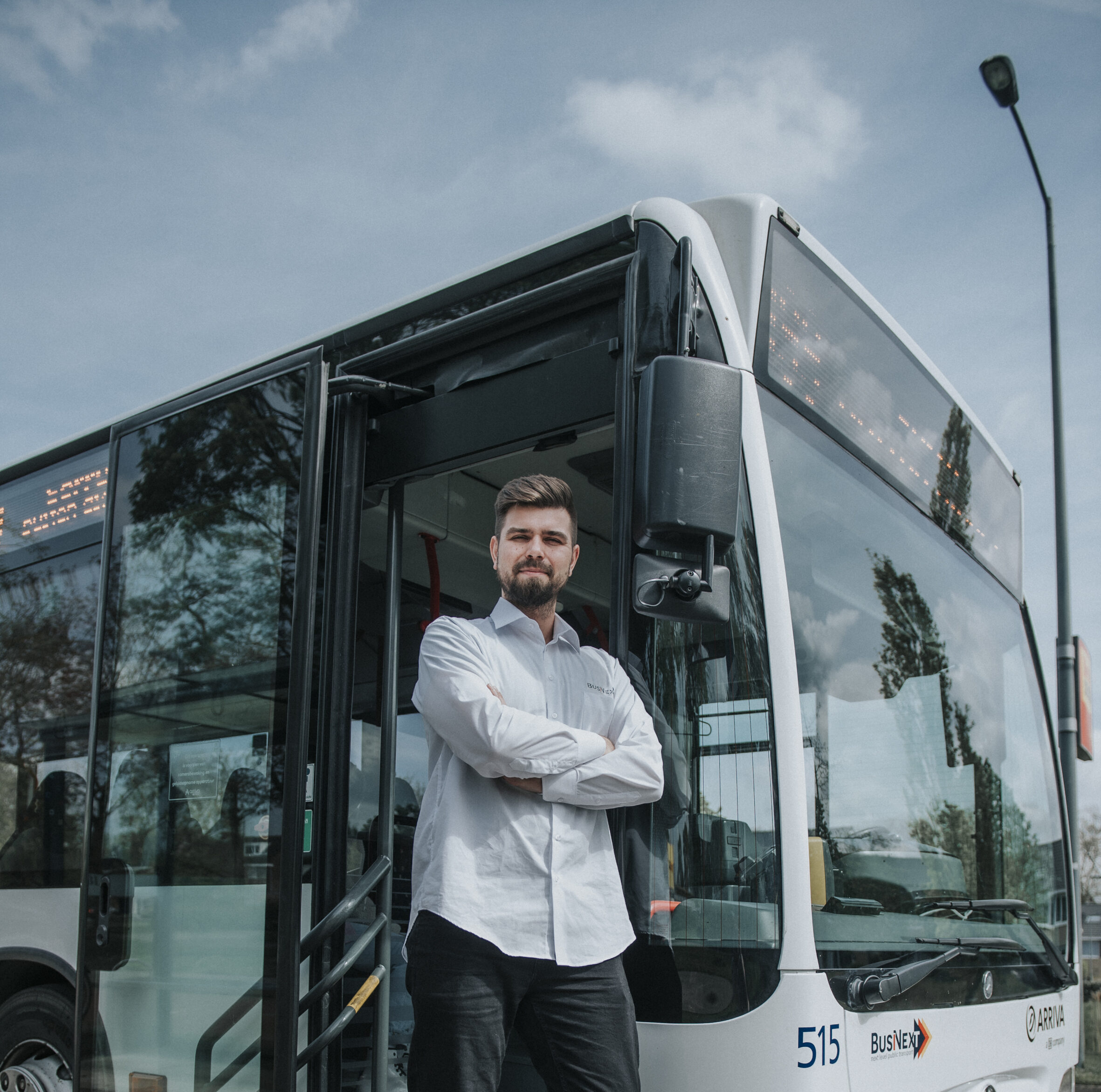 Man voor bus armen over elkaar